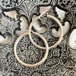 Large silver thick hoop earrings.